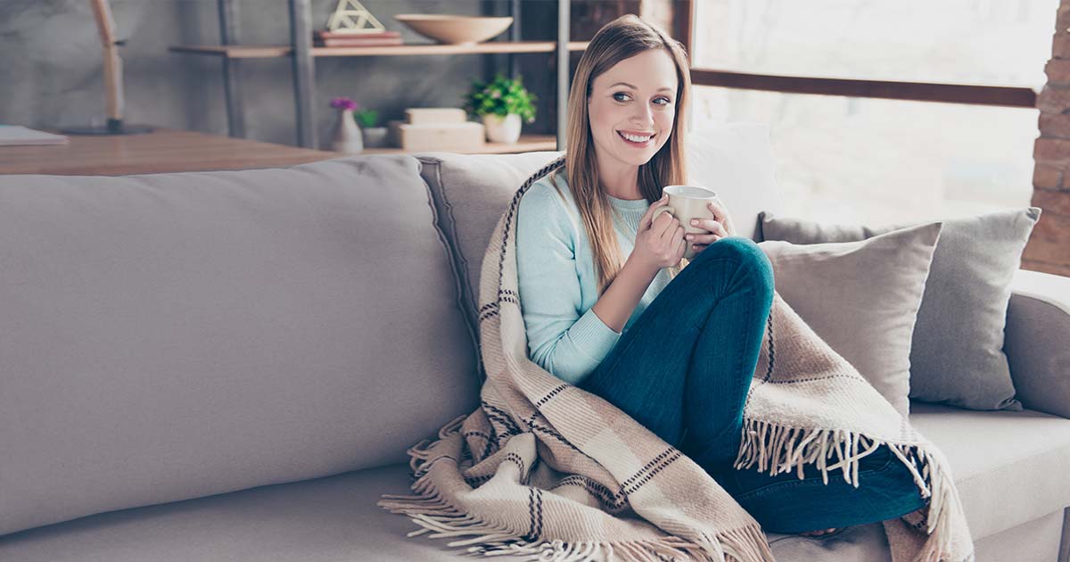 Woman relaxing on couch with a cup of tea