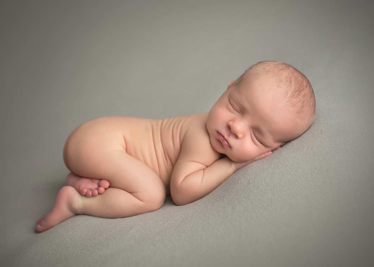 Baby infant boy sleeping on gray blanket