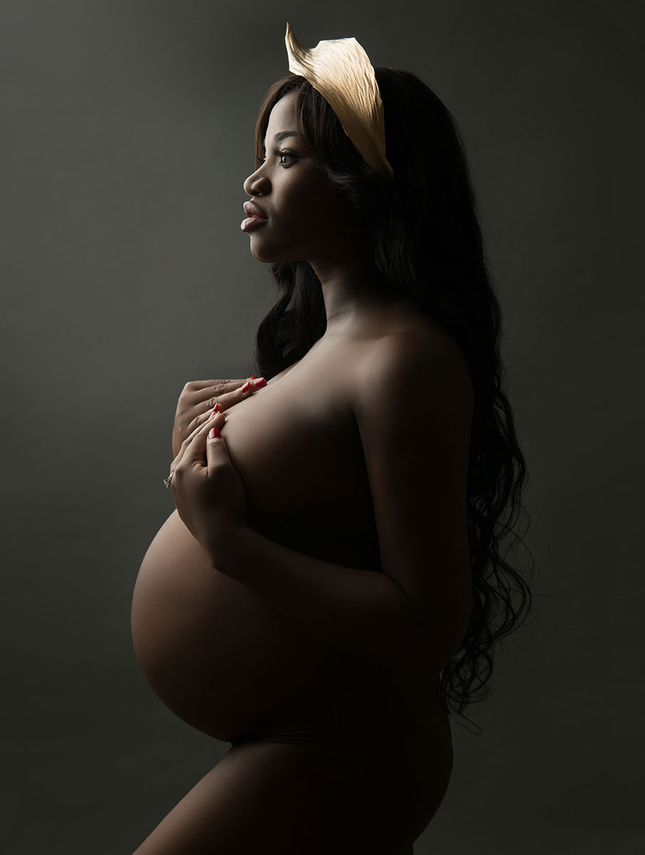 Ethnic woman with a hair accessory posing nude for her pregnancy photos