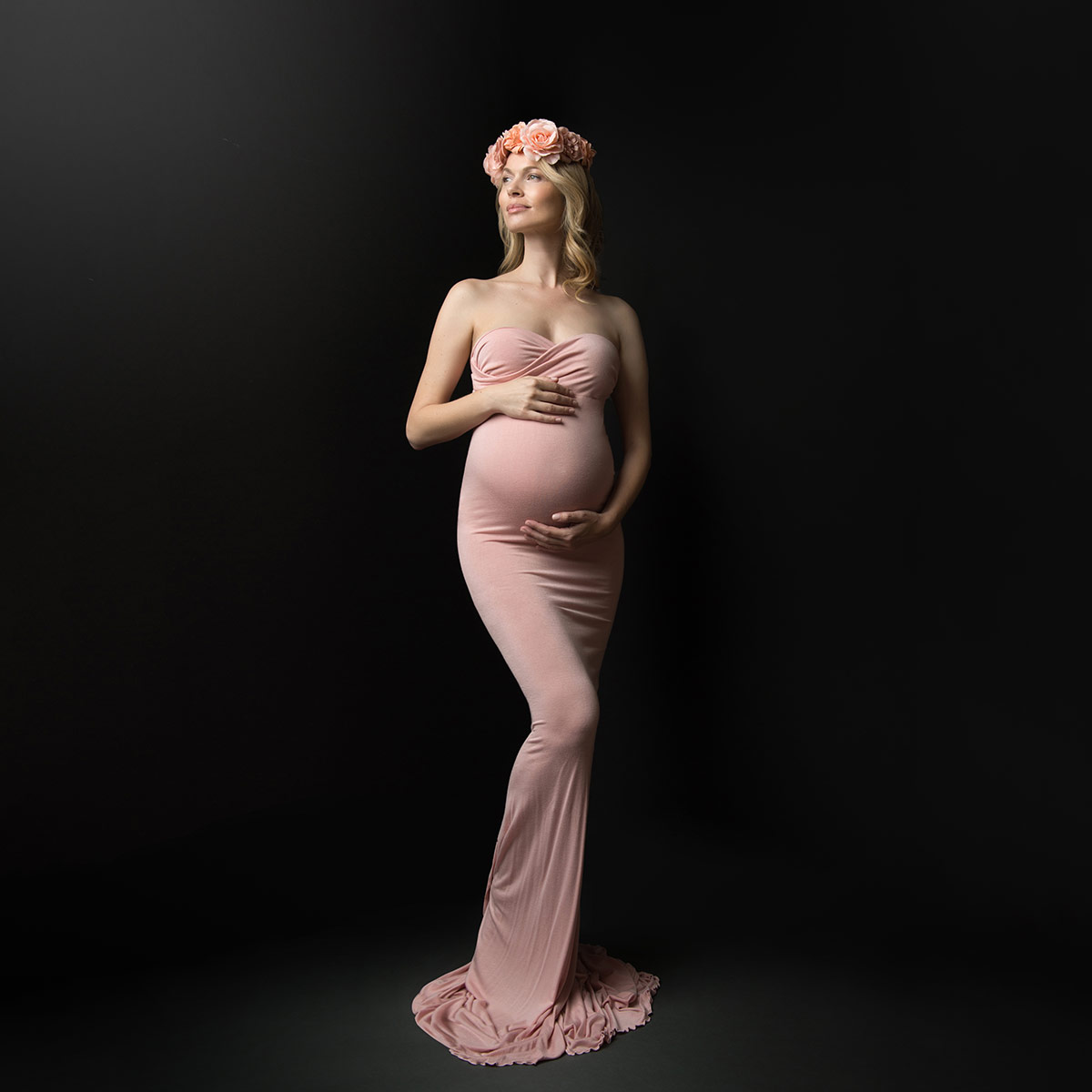 Pink dress worn by a pregnant woman with a headband