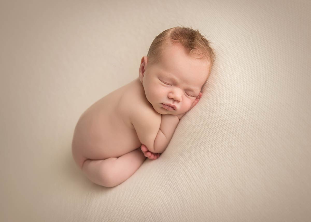 Newborn boy posing for a picture at a NYC newborn photography studio