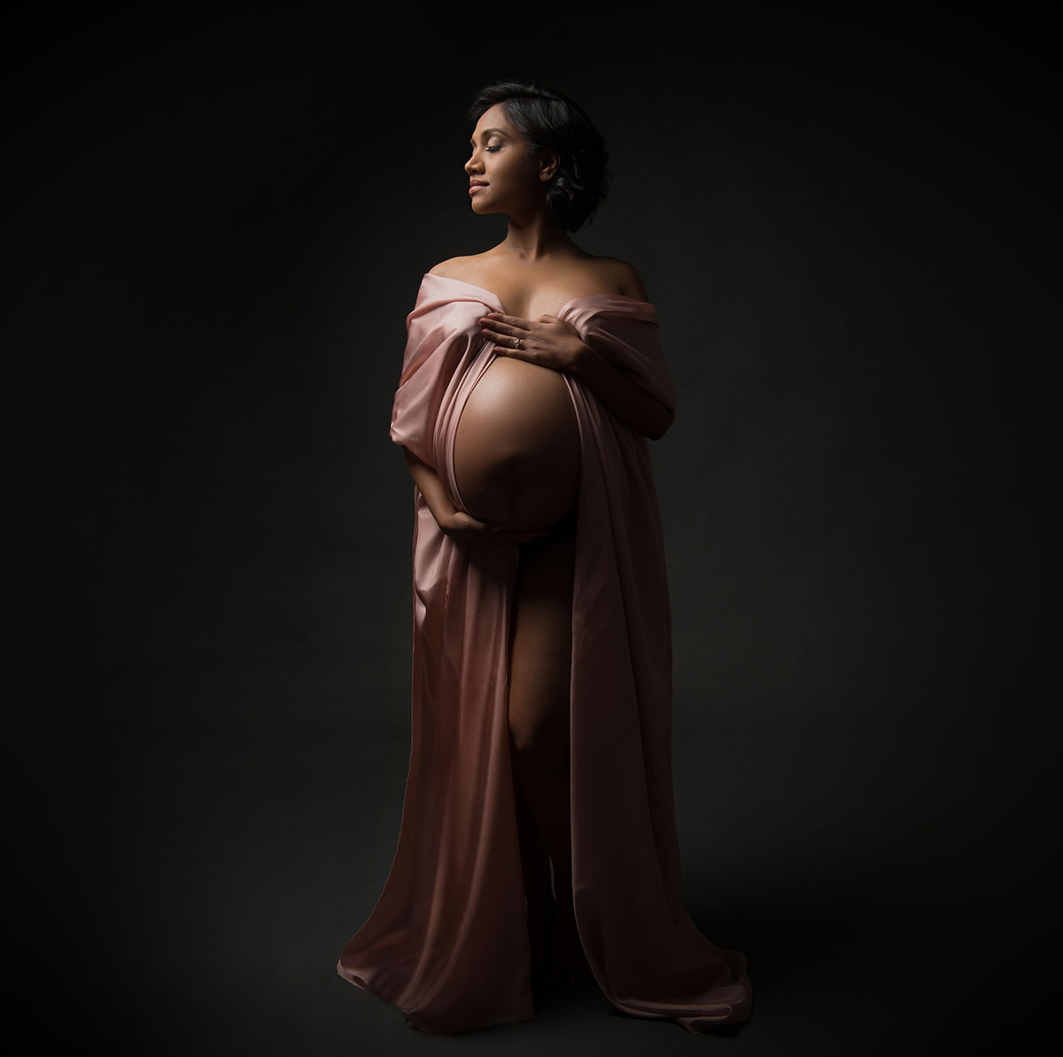 Beautiful pink fabric draped over a pregnant woman