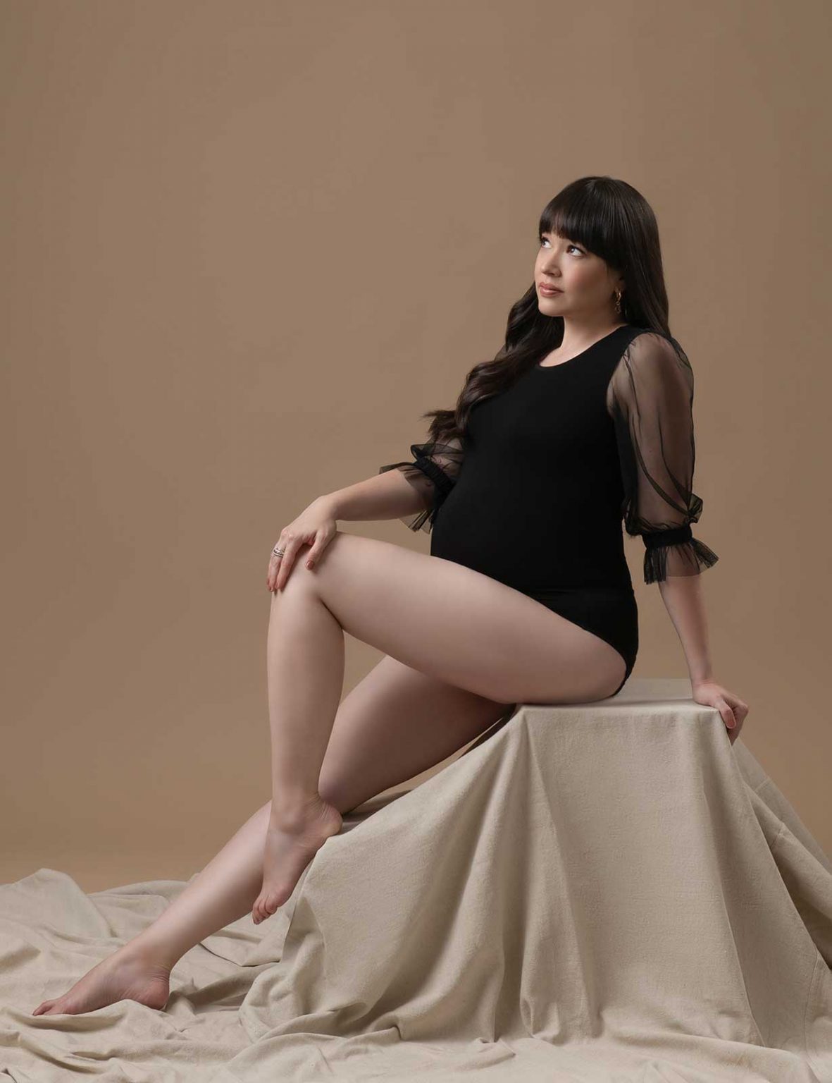 Maternity seated pose on posing block draped with canvas
