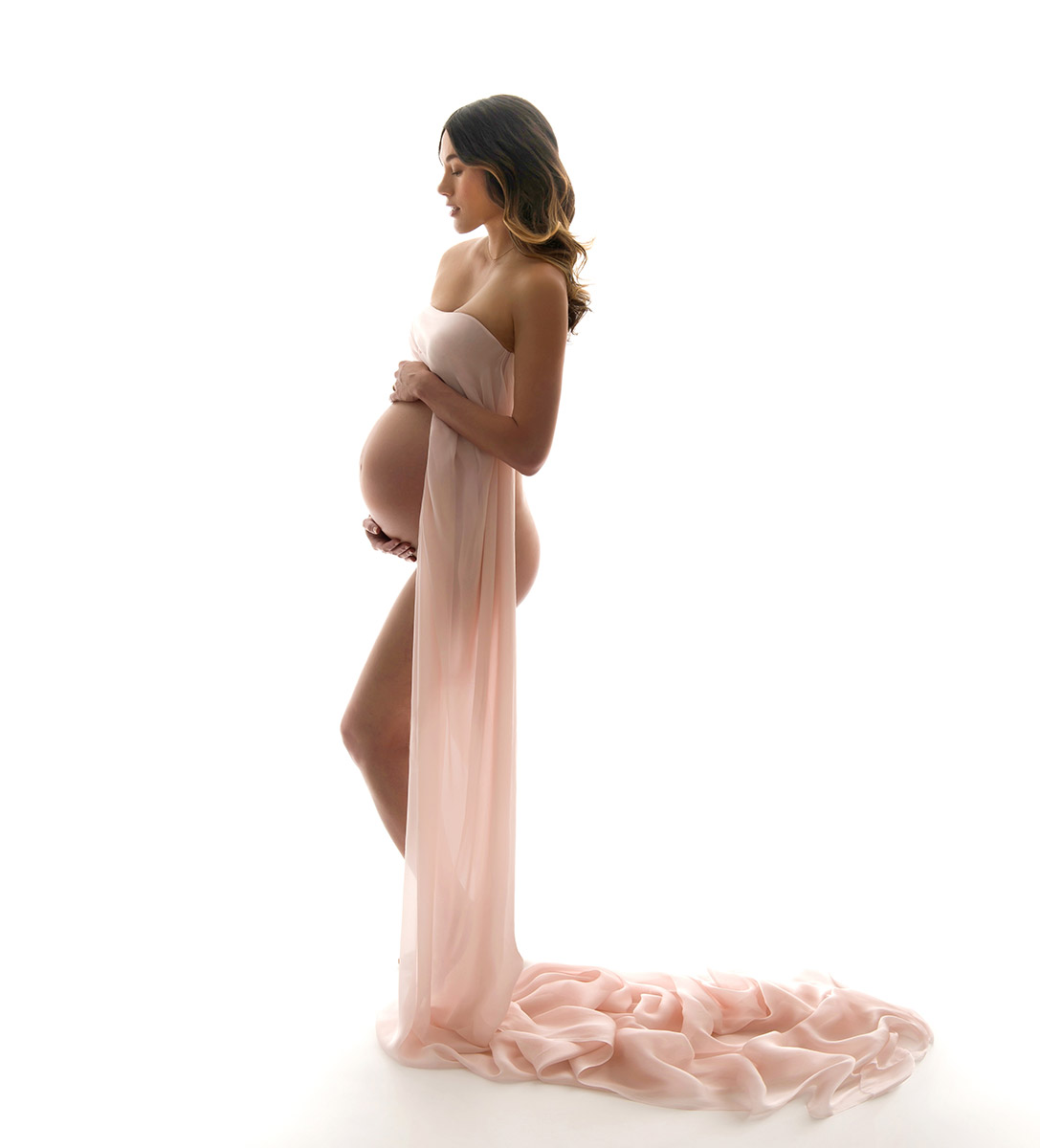 Natural maternity photo of a beautiful woman wearing draped fabric