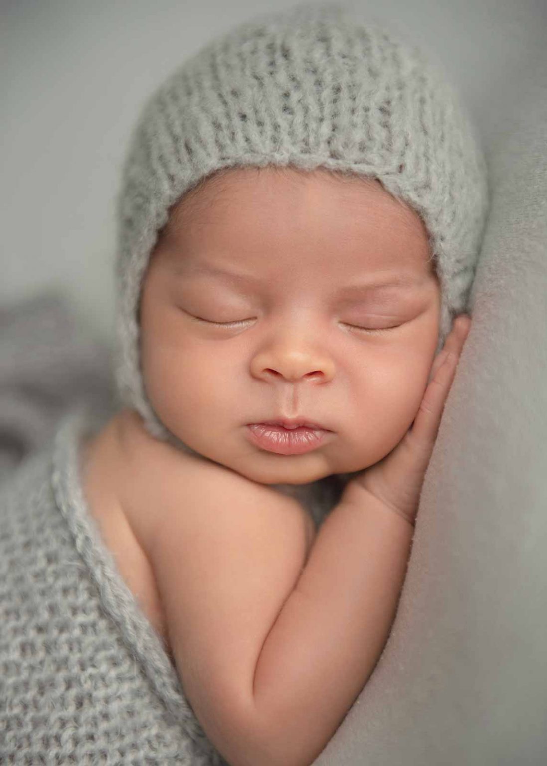 Adorable newborn boy sleeping at a photo studio