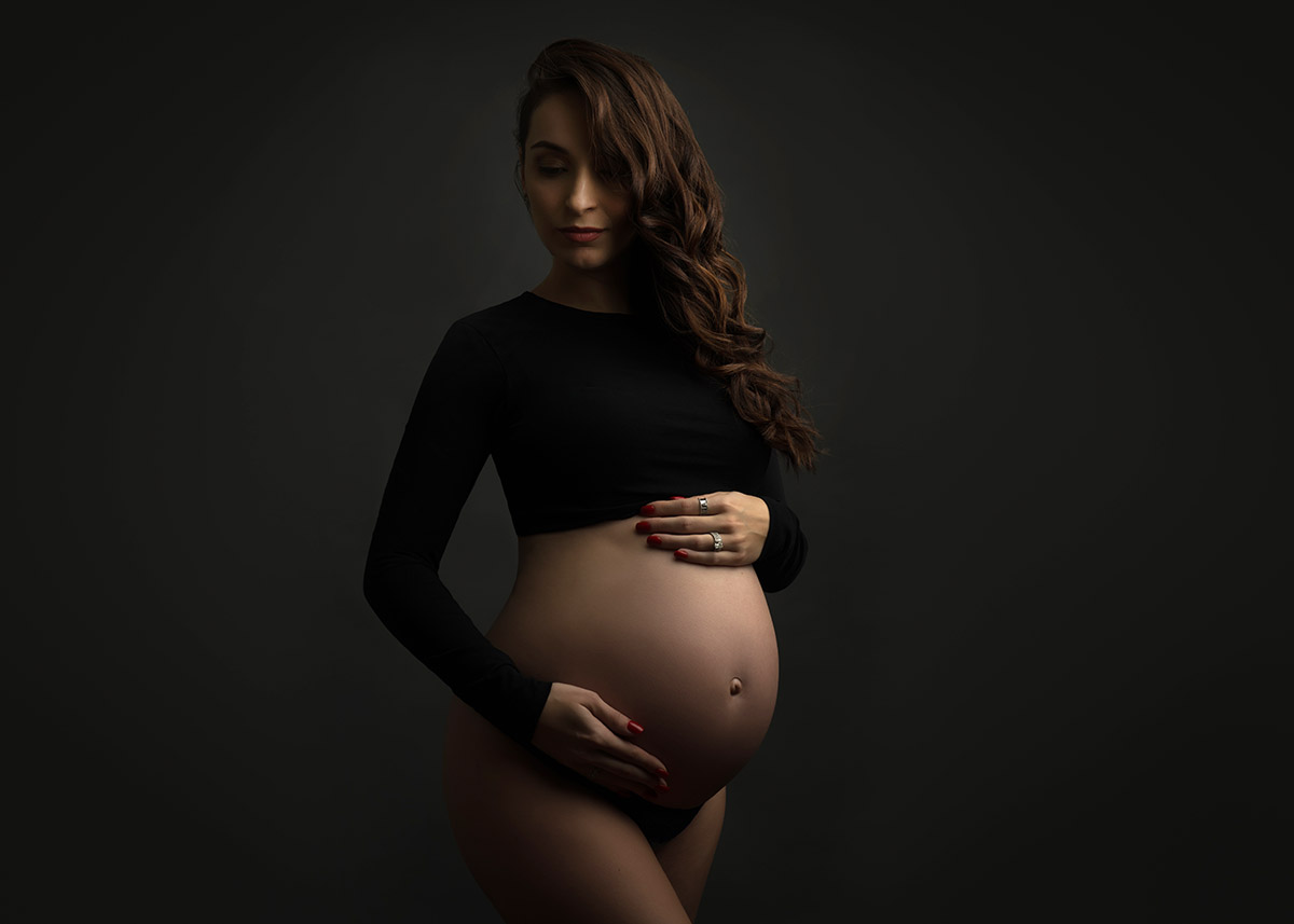 Maternity photo of a woman in a black crop top