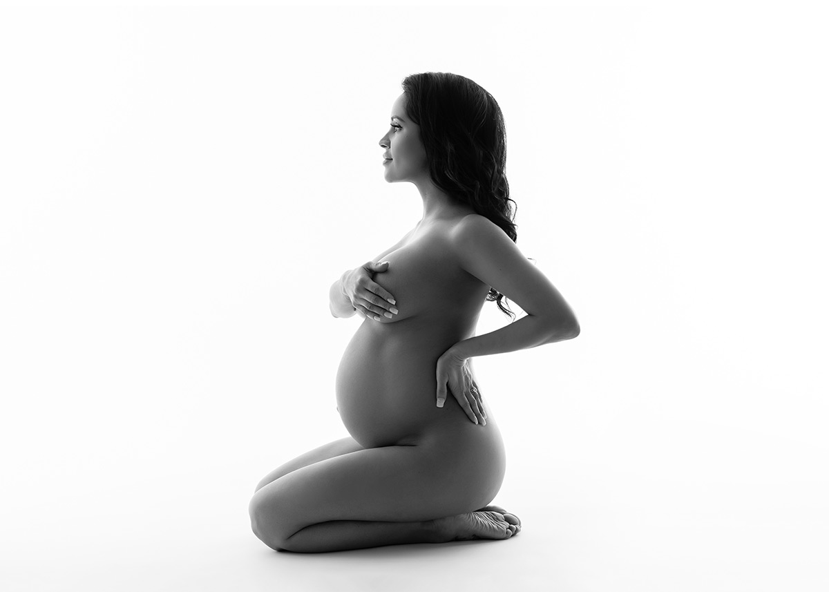 Pregnant woman sitting in a nyc photo studio