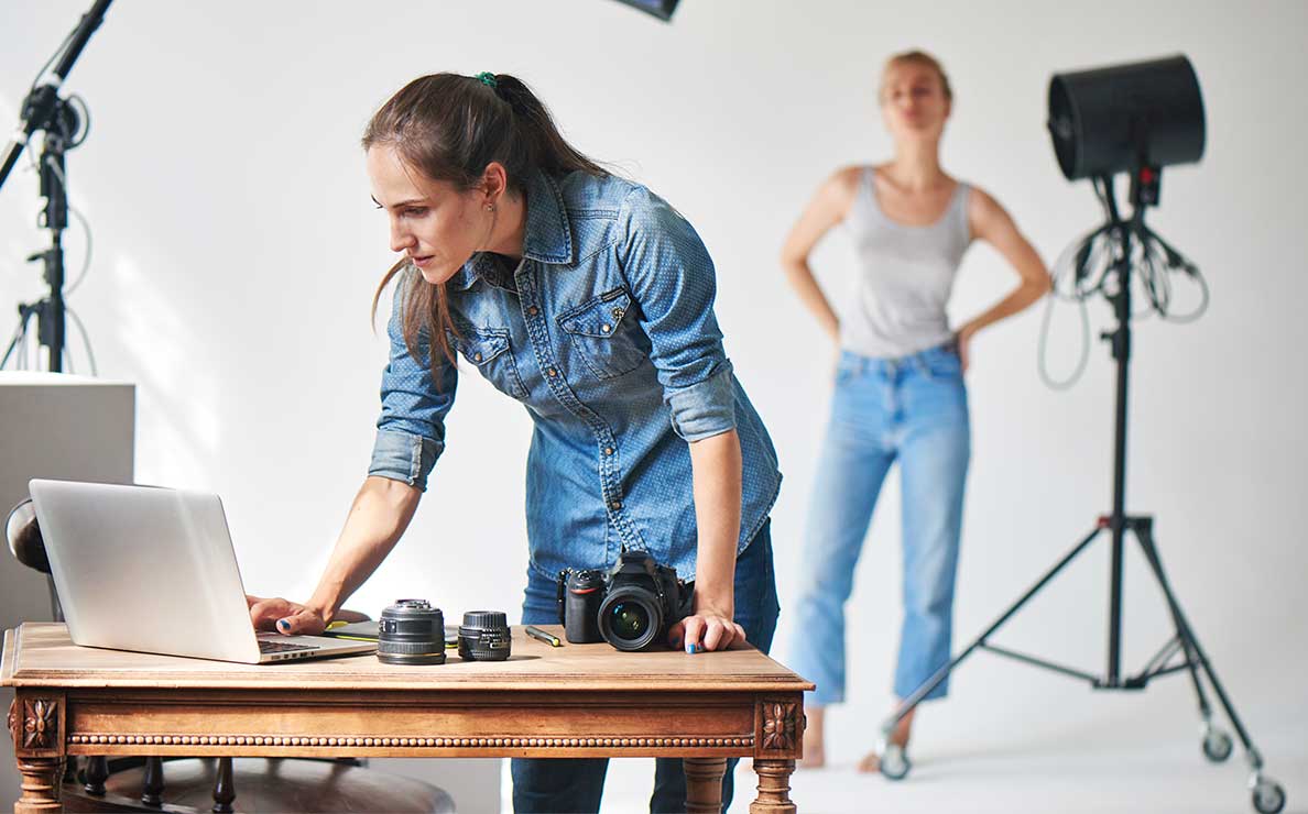 Photographer in a busy studio checking her laptop