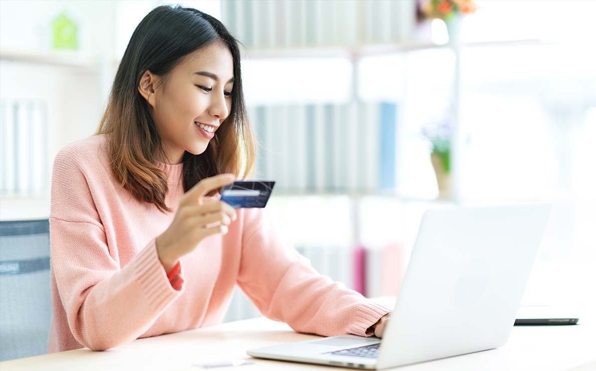 Pregnant woman shopping at her laptop with a credit card