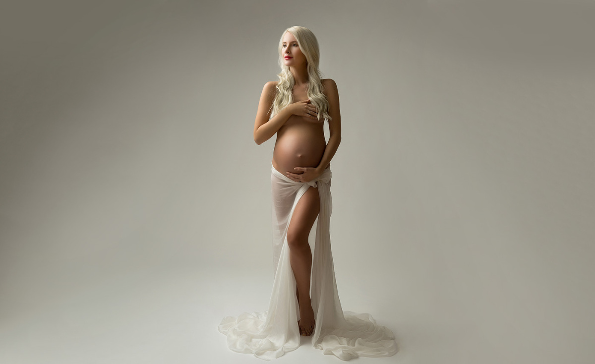Pregnant woman draped in white silk