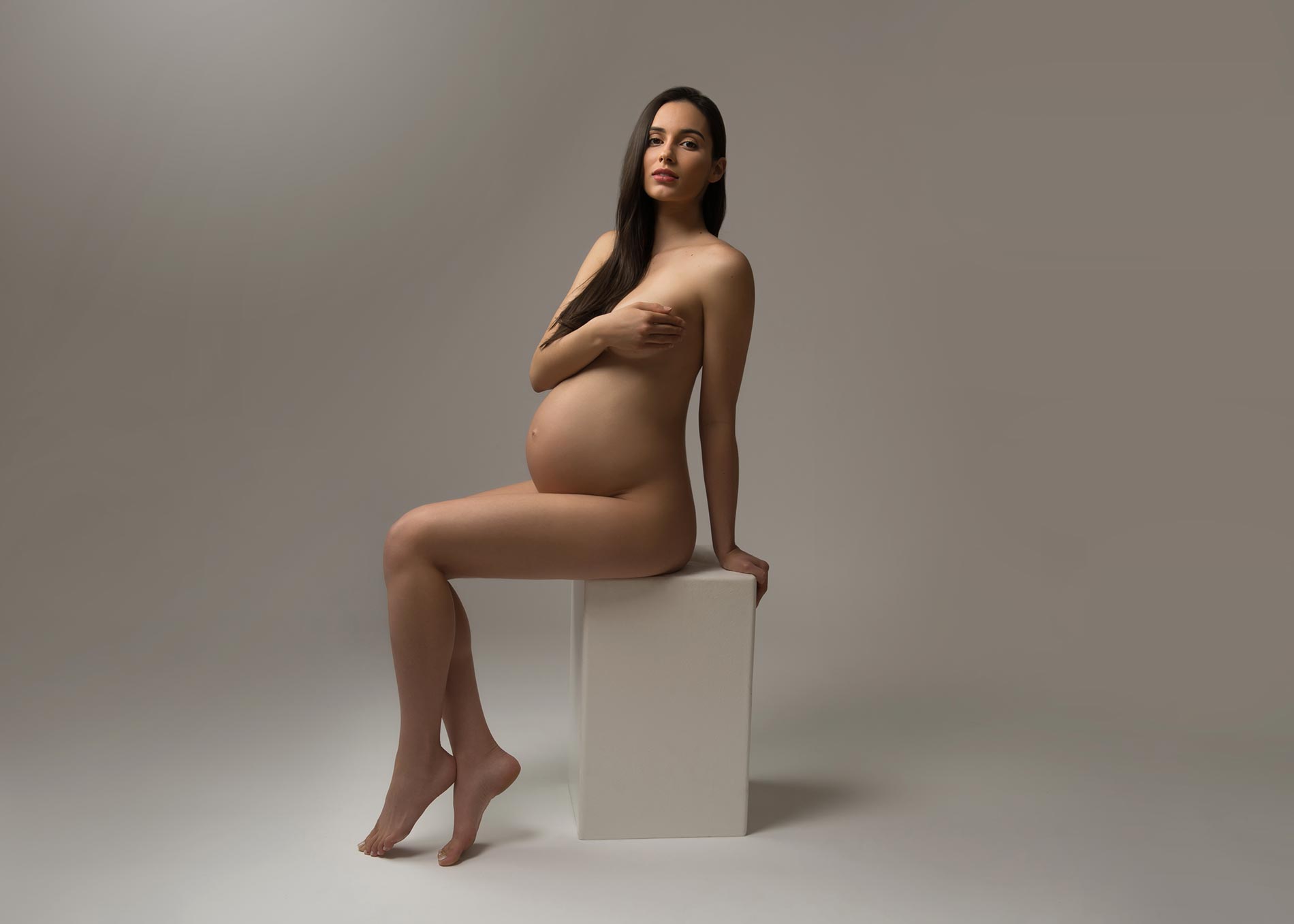 Pregnant woman posing for a maternity portrait at a NYC studio