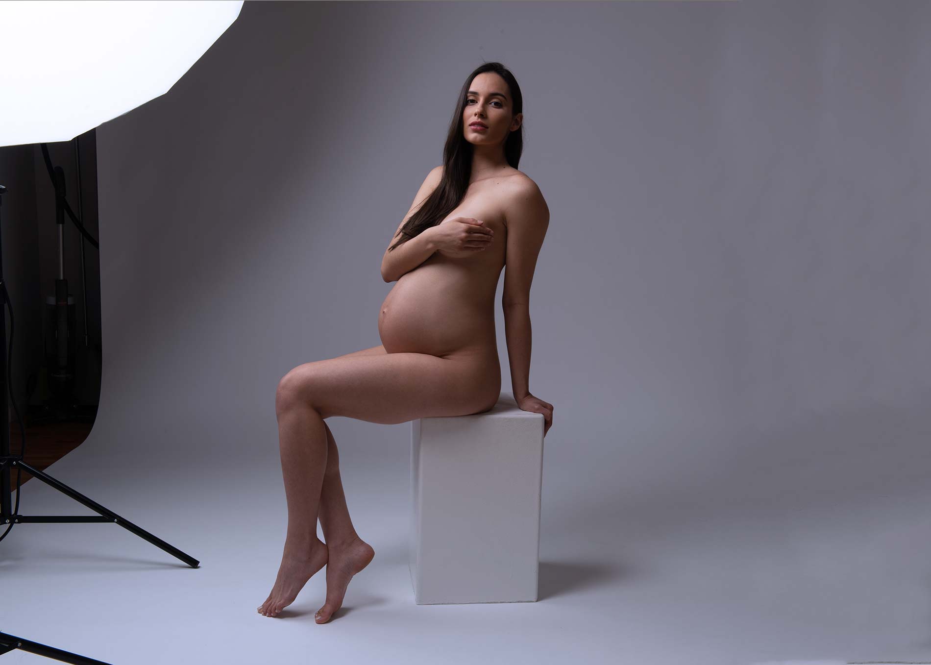 Pregnant woman posing for a maternity portrait at a NYC studio