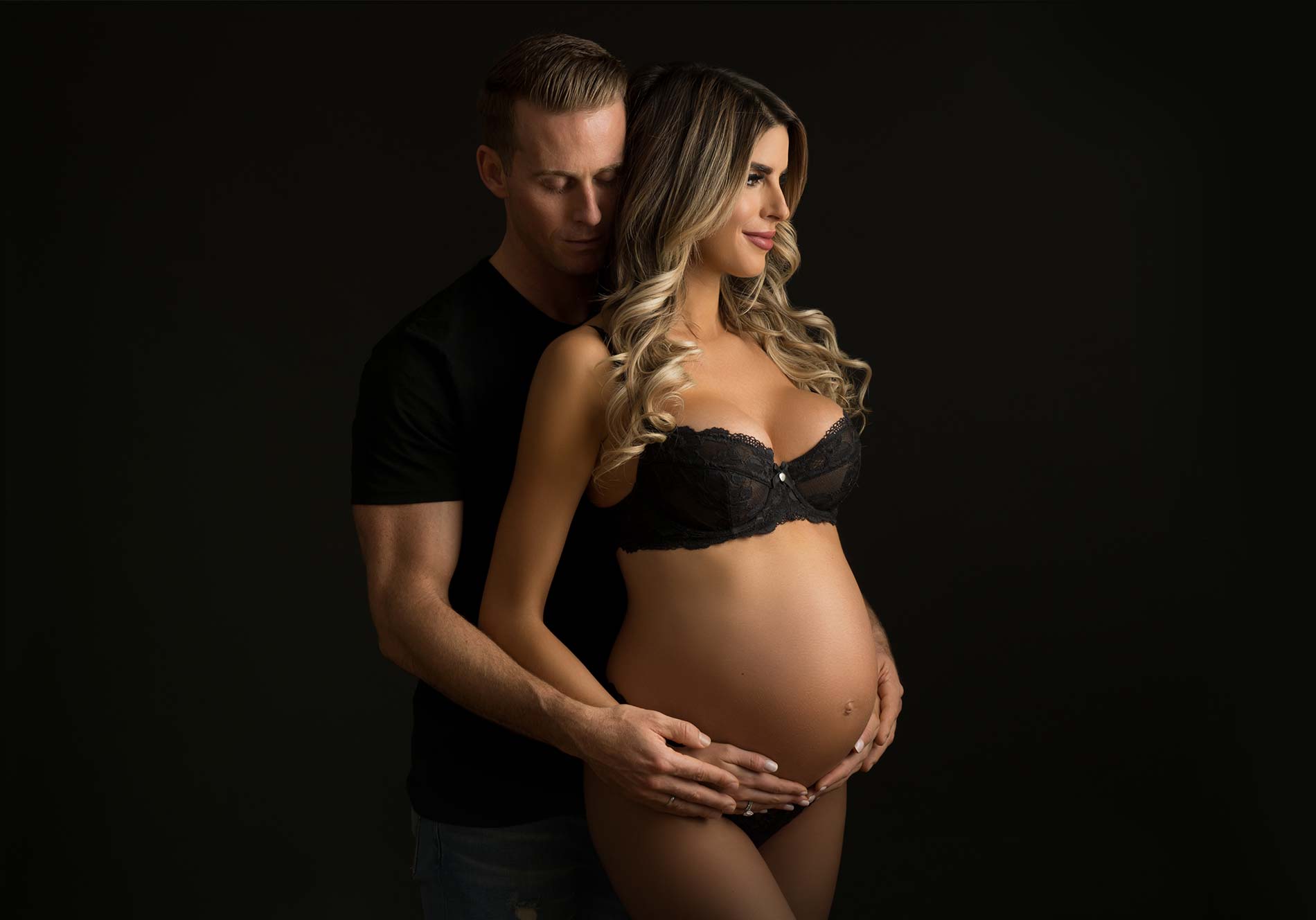 A couple expecting their first baby posing for a maternity photo