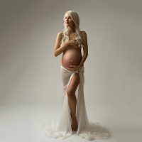 Woman in a draped fabric posing for a maternity photo