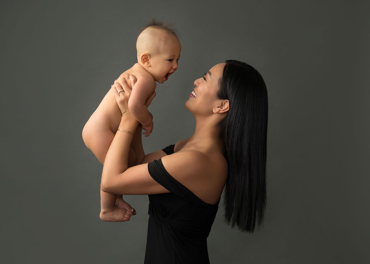 Happy mother holding up her son at a NYC photo studio