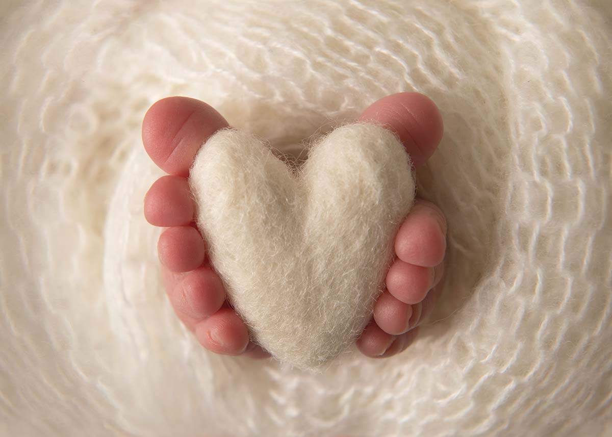 Baby toes holding a stuffed heart