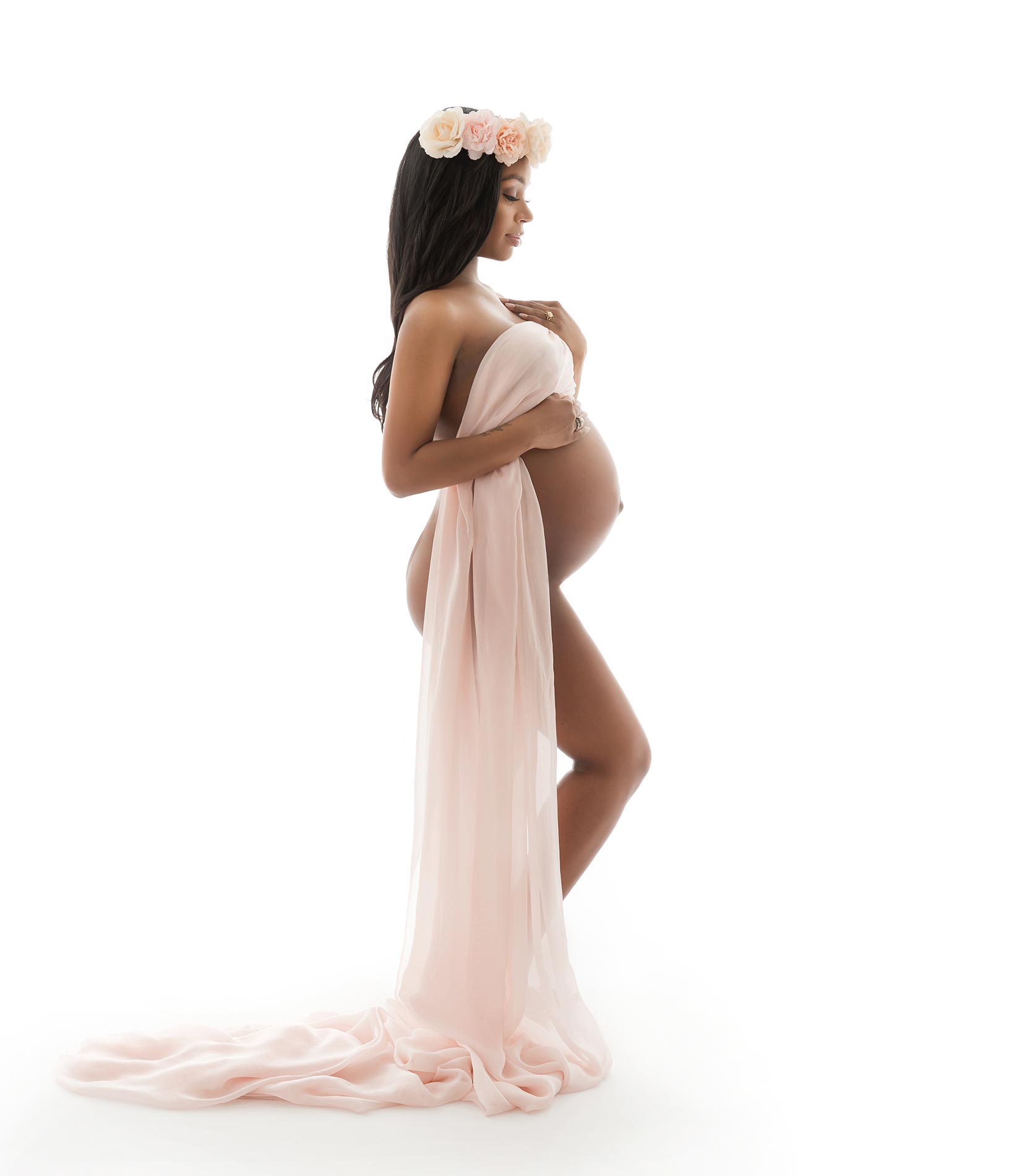 Pregnant woman at a NYC photo studio wearing a rose headpiece