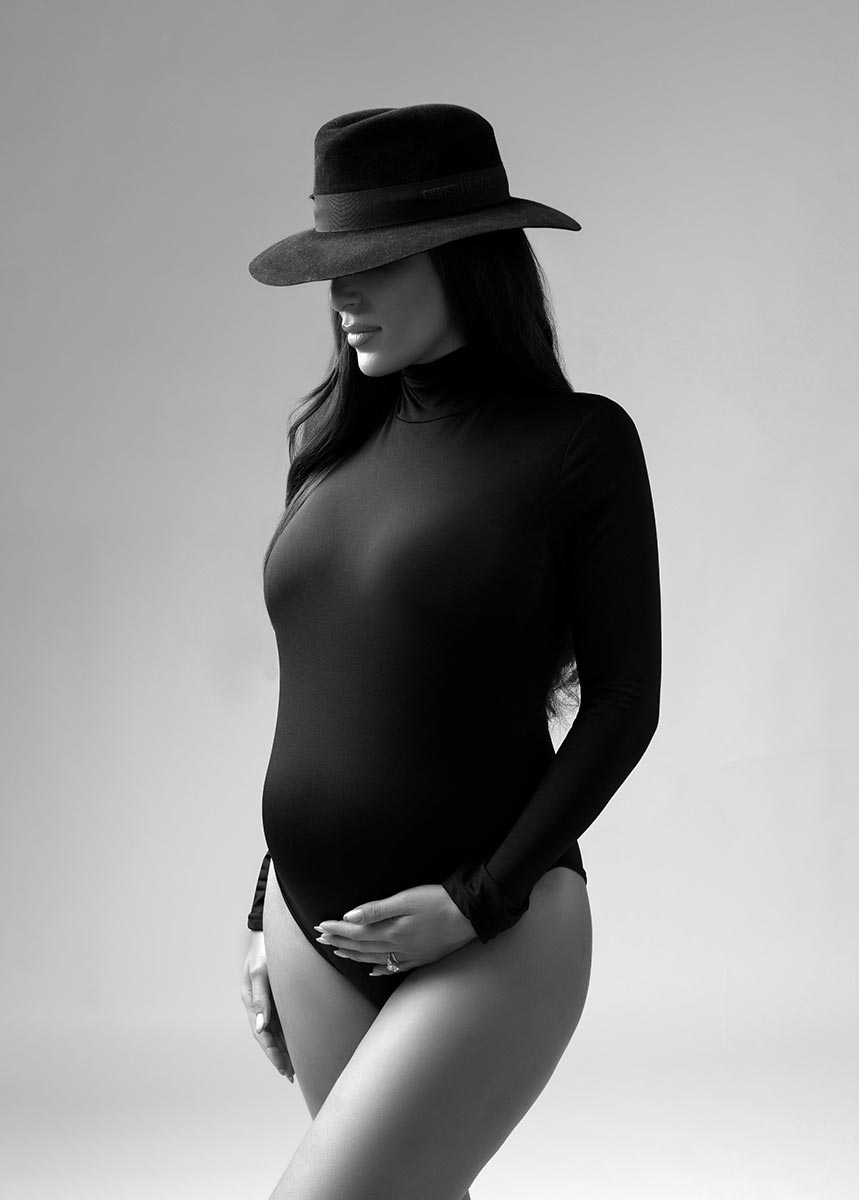 Maternity photo shoot of a woman in a stylish black hat