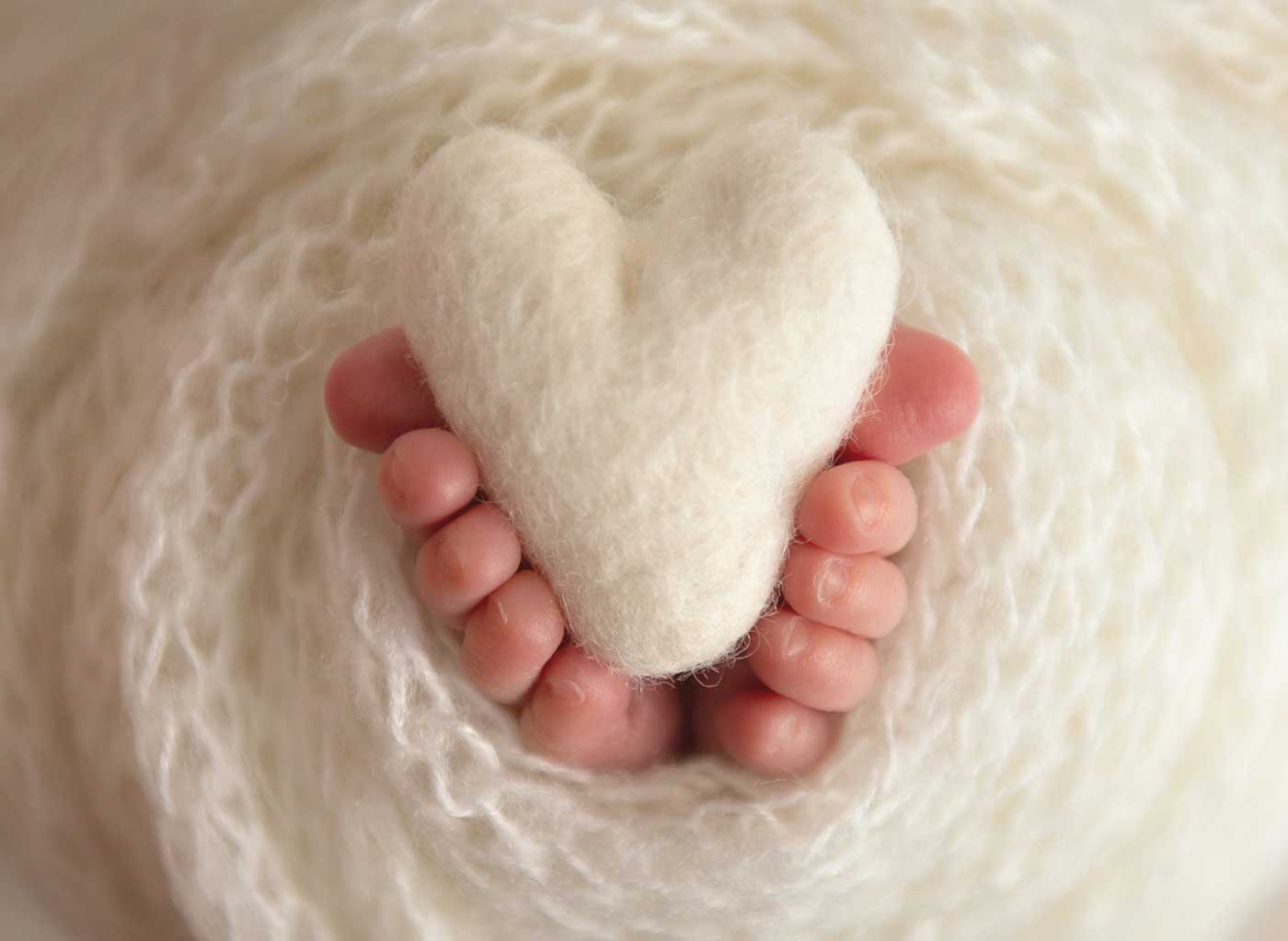 Fine art image of baby's toes wrapped around a heart