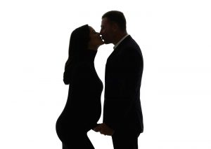 Husband kissing his pregnant wife during a maternity photo shoot in NYC