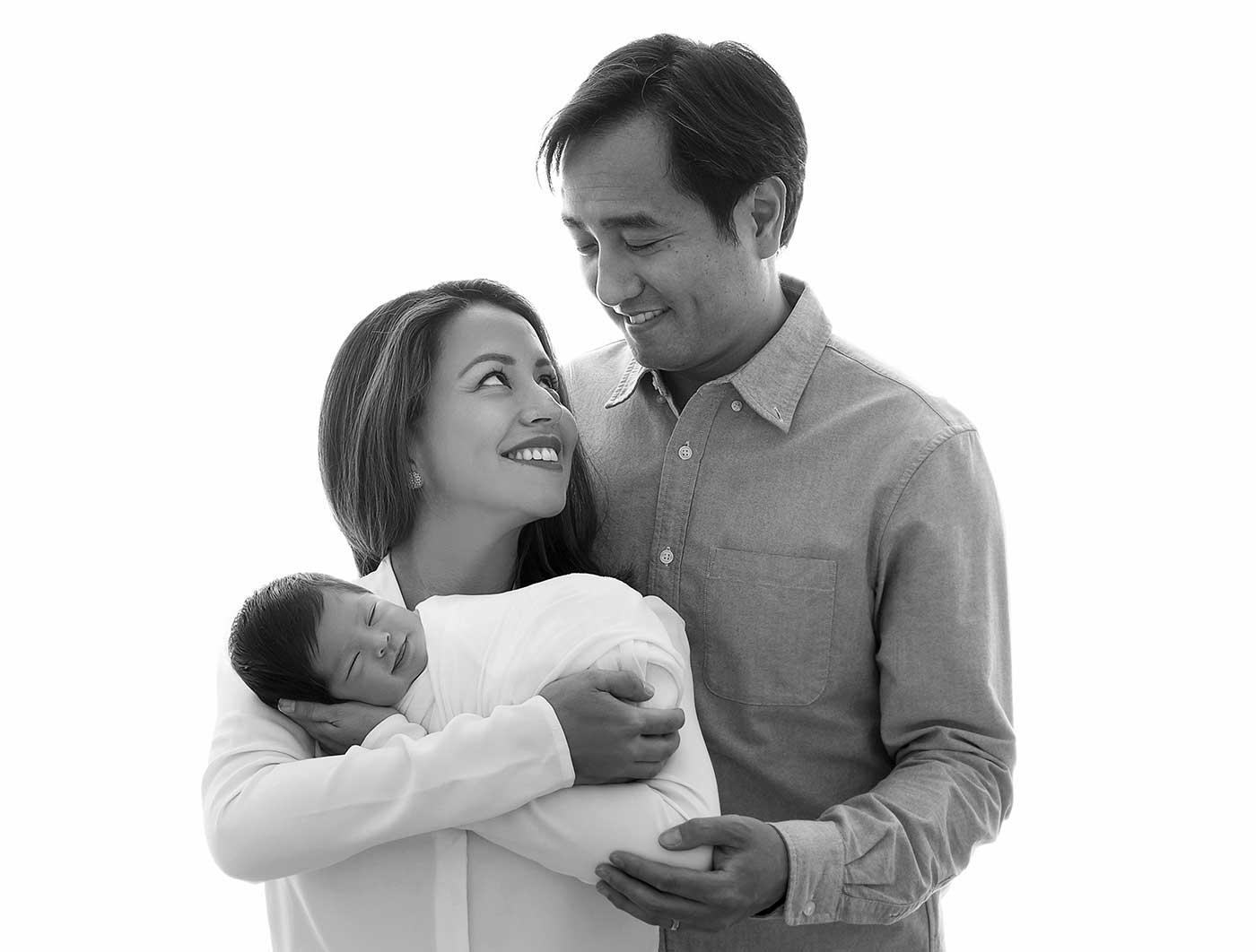 Timeless family portrait of a father, mother, and their newborn baby