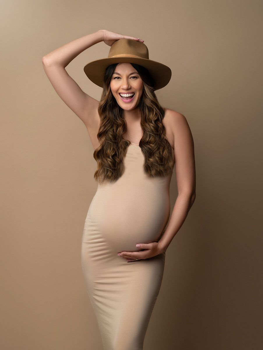 Smiling pregnant woman in a stylish hat