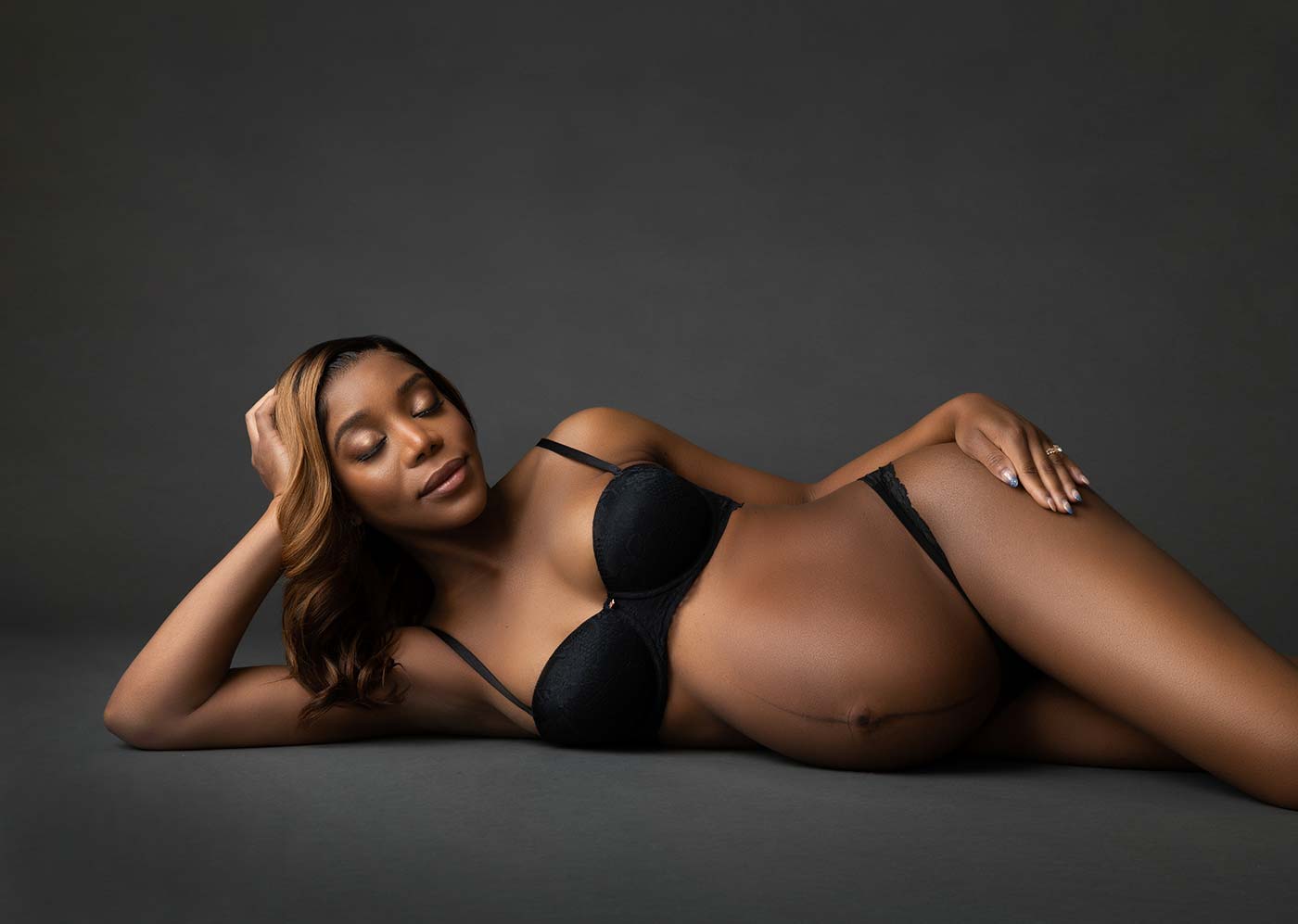 Pregnant woman laying on her side at a NYC photo studio
