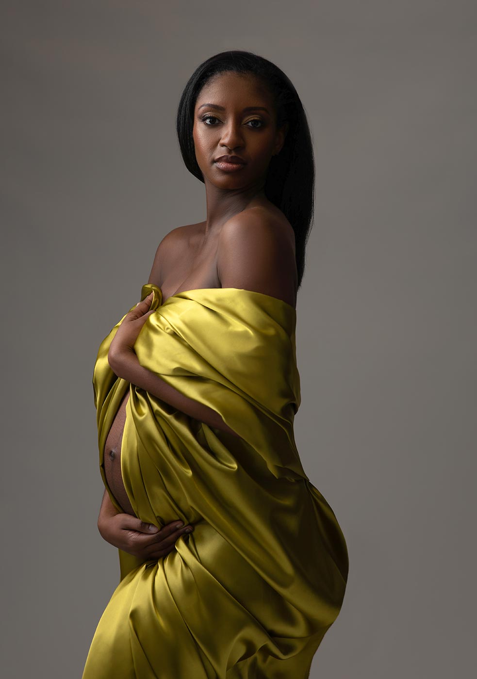Yellow silk fabric draped over maternity model