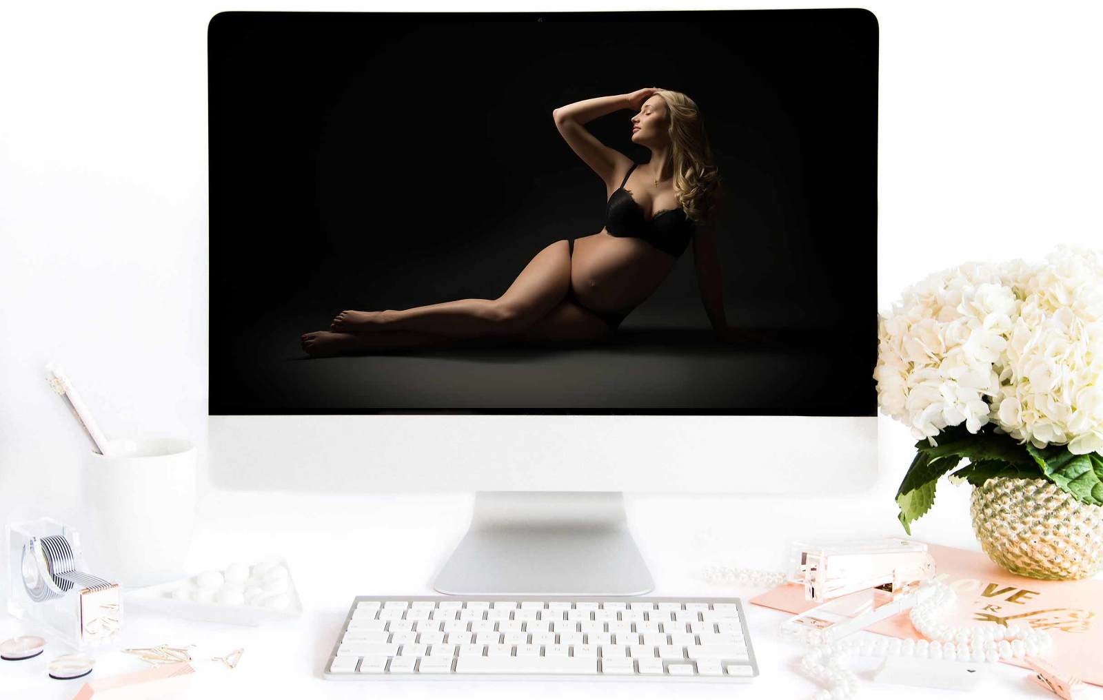 Computer screen showing a maternity photo of a pregnant woman laying on the floor